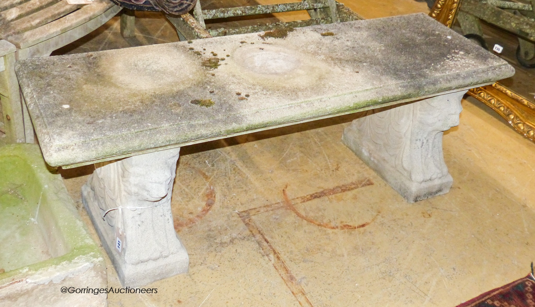 A reconstituted stone bench, with moulded rectangular top on stylised lion end supports, width 126cm, depth 41cm, height 44cm